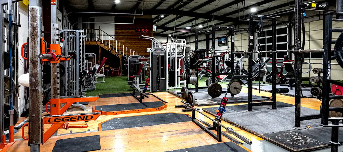 Power racks and a wood lifting platform running down the length of the floor, with loaded barbells racked either side.